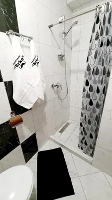 a bathroom with a shower and a toilet and towels at Apartmani Brko in Kotor-Varoš