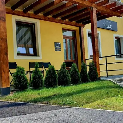 a building with a bunch of trees in front of it at Apartmani Brko in Kotor-Varoš