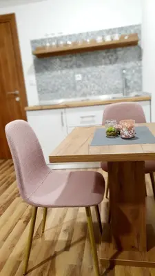 a wooden table with two chairs and a wooden table with a plate on it at Apartmani Brko in Kotor-Varoš