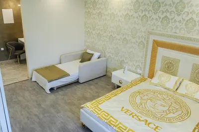 a hotel room with two beds and a chair at Apartmani President V in Banja Luka