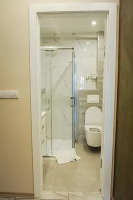 a bathroom with a shower and a white toilet at Apartmani President V in Banja Luka