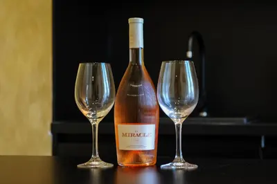 a bottle of wine and two wine glasses on a table at Apartmani President V in Banja Luka