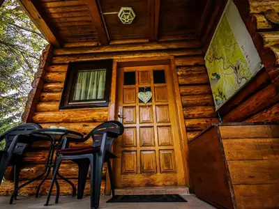 a cabin with a door and chairs in front of it at Home Eden Dobrenica in Bihać