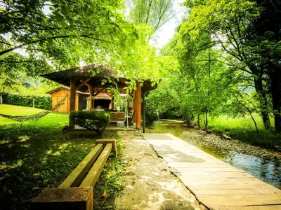 a small building in a park with a walkway at Home Eden Dobrenica in Bihać