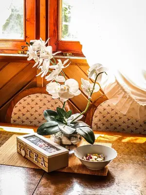 a table with a box and flowers on it at Home Eden Dobrenica in Bihać