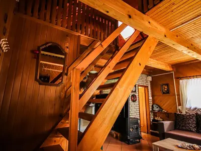 a wooden staircase in a cabin with a living room at Home Eden Dobrenica in Bihać