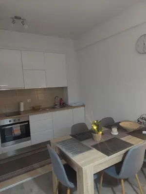 a kitchen with a wooden table and chairs at Apartman Tea in Kupres