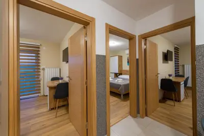 a room with a bedroom and a bed and a desk at Sobe Mili Ozren in Doboj