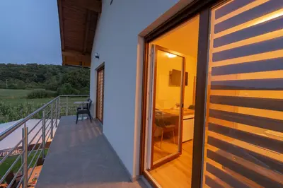 a room with a balcony with a desk and a window at Sobe Mili Ozren in Doboj