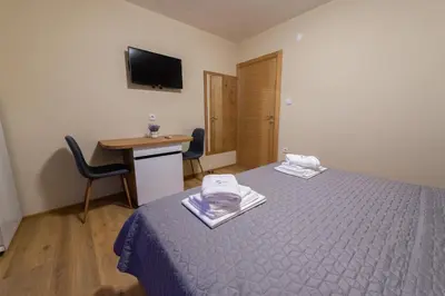 a room with a bed and a desk and a television at Sobe Mili Ozren in Doboj