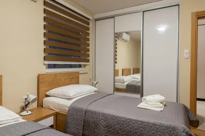 a bedroom with two beds and a mirror at Sobe Mili Ozren in Doboj