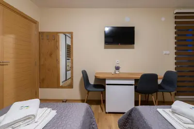 a bedroom with a bed and a desk and a tv at Sobe Mili Ozren in Doboj