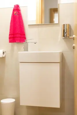 a bathroom with a white sink and a red towel at Sobe Mili Ozren in Doboj