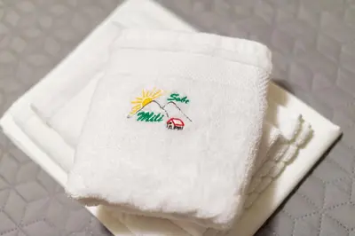 a towel with a napkin with a house on it at Sobe Mili Ozren in Doboj