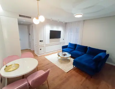 a living room with a blue couch and a table at Premium Apartmani Banja Luka in Banja Luka