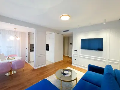 a living room with a blue couch and a table at Premium Apartmani Banja Luka in Banja Luka