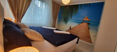 a bedroom with a bed with a view of a house at Lux Apartment ll Prijedor in Prijedor