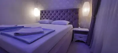 a bedroom with a large white bed with a headboard at Lux Apartment ll Prijedor in Prijedor