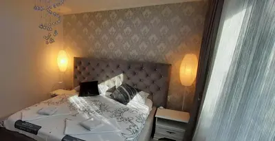 a bedroom with a large bed with white sheets and pillows at Lux Apartment ll Prijedor in Prijedor