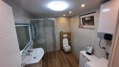 a bathroom with a toilet and a shower and a sink at Lux Apartment ll Prijedor in Prijedor