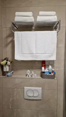 a bathroom with towels hanging on a rack at Tuzla Trg - Tuzla Square in Tuzla