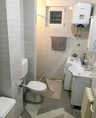 a small bathroom with a toilet and a sink at Apartman Dunja in Prijedor
