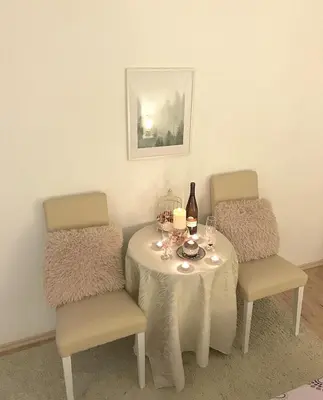 a dining room table with two chairs and a table with wine glasses at Apartman Dunja in Prijedor