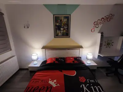 a bedroom with a bed with two tables and two lamps at Stan na dan Apartman KRISFIL Prnjavor in Prnjavor
