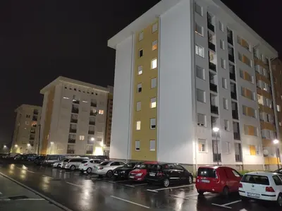 a large white building with cars parked in a parking lot at S&S Apartman Banja Luka in Banja Luka