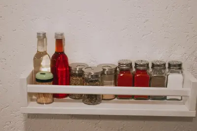 a shelf with bottles and jars of spices at Take it easy Apartment in Visoko