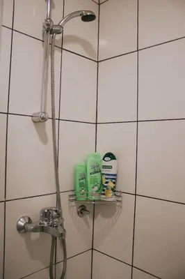 a shower in a bathroom with white tiles at Take it easy Apartment in Visoko