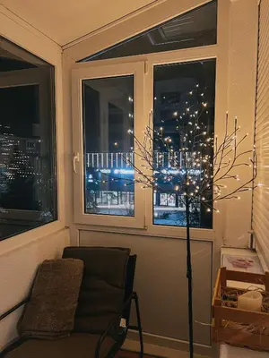 a room with a chair and a window with a tree at Take it easy Apartment in Visoko