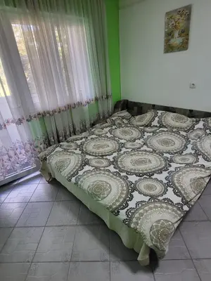 a bed sitting in a room with a window at Stan u centru Prnjavor in Prnjavor