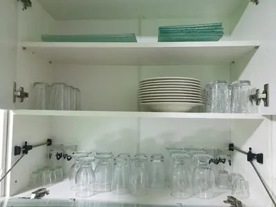 a shelf filled with clear glass jars and plates at Stan u centru Prnjavor in Prnjavor