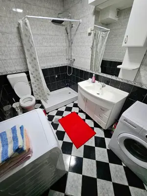 a bathroom with a black and white checkered floor at Stan u centru Prnjavor in Prnjavor