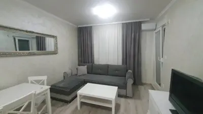 a living room with a couch and a tv at Apartman Basic 2 in Doboj