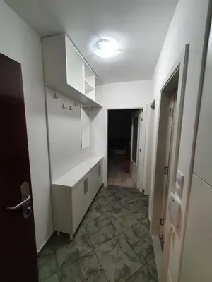 a kitchen with white cabinets and a hallway at Apartman Basic 2 in Doboj