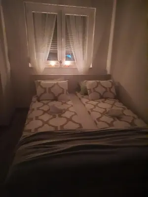 a small bedroom with a bed with a window at Apartman Basic 2 in Doboj