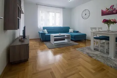 a living room with a blue couch and a table at Iskra in Banja Luka