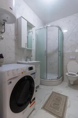 a washing machine in a bathroom with a shower at Iskra in Banja Luka