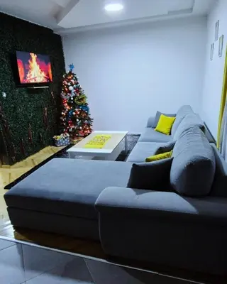 a living room with a couch and a christmas tree at Apartman Teddy12-Vlašić in Vlasic
