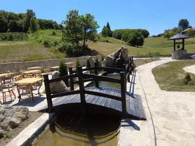 a water fountain with tables and chairs in a garden at MOTEL ALADIN in Cazin
