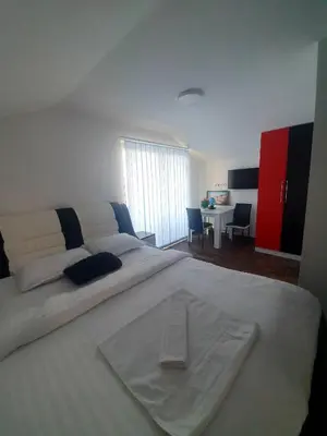 a large white bed in a room with a desk at MOTEL ALADIN in Cazin