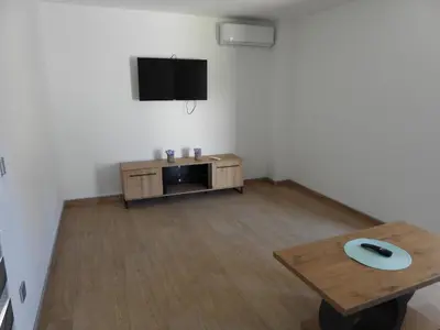 a living room with a table and a flat screen tv at MOTEL ALADIN in Cazin