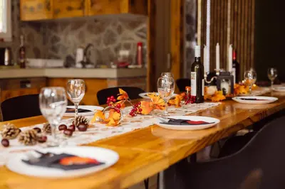 a long wooden table with plates of food and wine glasses at Srce Kozare in Prijedor