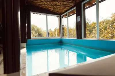 a swimming pool in a house with windows at Srce Kozare in Prijedor