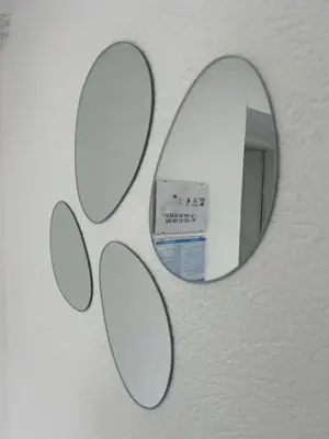 a mirror on a wall with four circles on it at Apartmani Star in Tuzla
