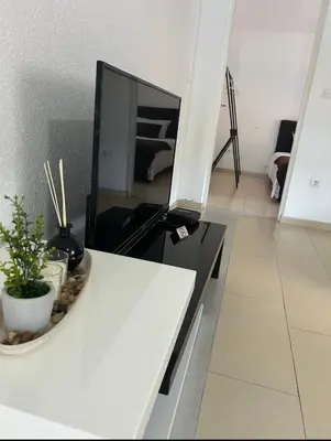 a kitchen with a white counter top with a tv at Apartmani Star in Tuzla