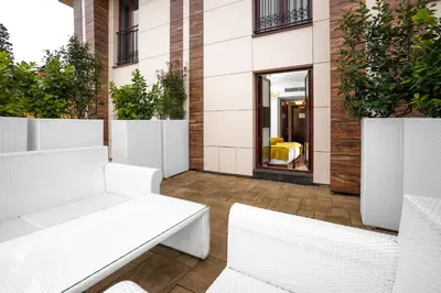a patio with white benches and plants at Hotel Integra Banja Luka in Banja Luka
