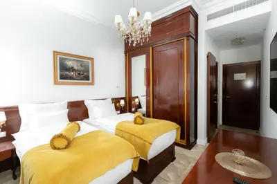 a bedroom with two beds and a chandelier at Hotel Integra Banja Luka in Banja Luka